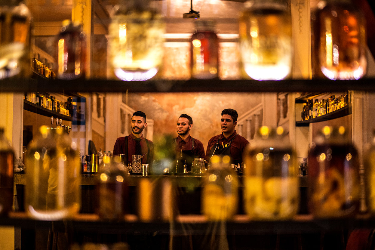 Prateleiras e baristas do Alquimico Bar em Cartagena