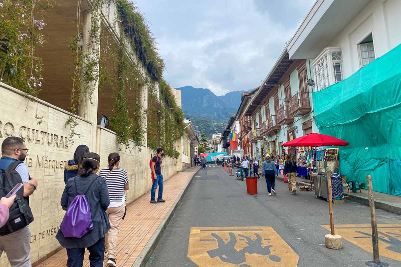 Pessoas caminhando no tour da arte de rua em Bogotá